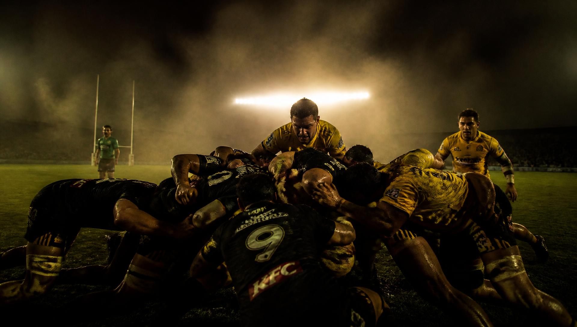 Les joueurs de Carcassonne XIII en mêlée sous les projecteurs du stade